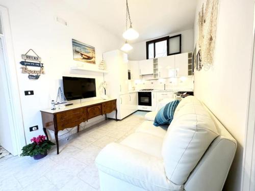 a living room with a white couch and a desk at Casa Marilyn in Ascea