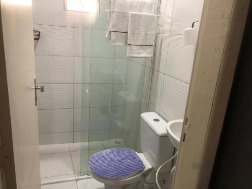 a bathroom with a shower and a toilet with a purple seat at Portuga Flat - Olinda in Olinda