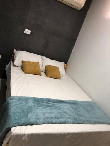 a white bed with two pillows on top of it at Portuga Flat - Olinda in Olinda