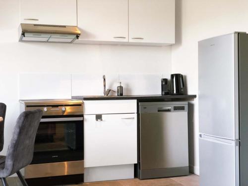 a kitchen with white cabinets and a refrigerator at Guesthouse ML in Hillegom