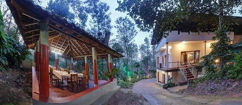 an exterior view of a house with tables and chairs at Royal Woods Coorg in Madikeri