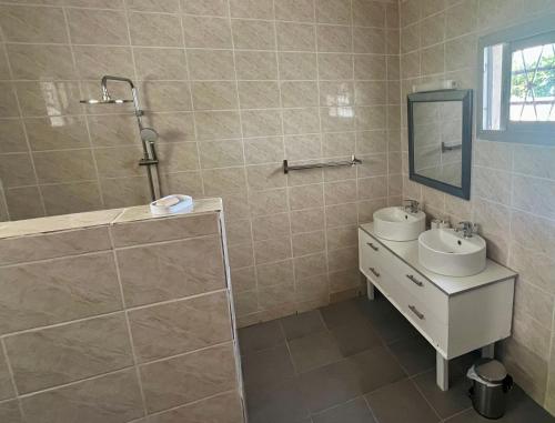 a bathroom with a sink and a mirror at Résidence Créolia in Kribi
