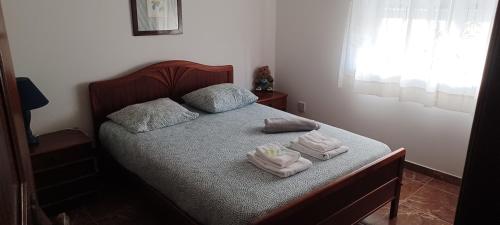 Un dormitorio con una cama con toallas. en SwordFish Cliff Apartment, en Peniche