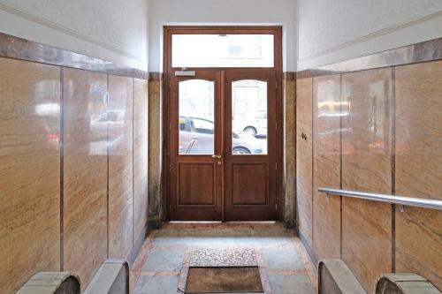 Un pasillo con una puerta de madera con una ventana. en Apartment Filip, en Belgrado