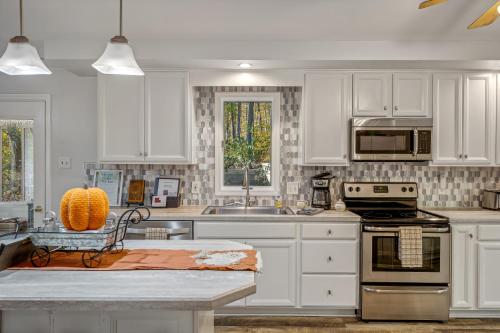 a kitchen with white cabinets and stainless steel appliances at Herons Rest -- Riverfront, Fire Pit, All seasons Porch, Grill, Games, Fishing, Deck, Wifi, River view in Great Cacapon