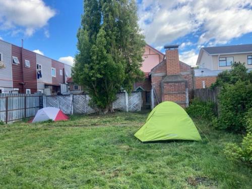 una tenda verde nel cortile di una casa di erratic rock a Puerto Natales