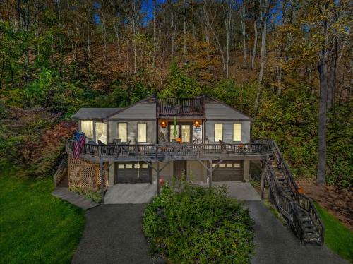 a large house with a balcony on a bridge at Herons Rest -- Riverfront, Fire Pit, All seasons Porch, Grill, Games, Fishing, Deck, Wifi, River view in Great Cacapon