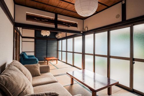 a living room with a couch and a table at Japanese Local House - 奥葉山の一棟貸しの隠れ家宿 - 静かな縁側と和室 in Hayama