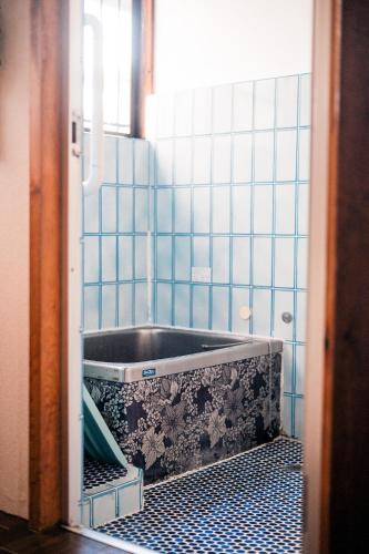 a bathroom with a tub in a blue tiled room at Japanese Local House - 奥葉山の一棟貸しの隠れ家宿 - 静かな縁側と和室 in Hayama