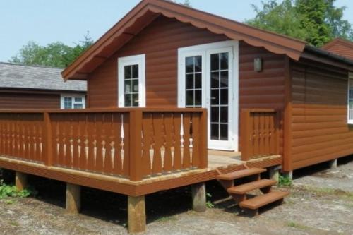 a log cabin with a porch and a deck at Cosy log cabin in Snowdonia 357 in Trawsfynydd