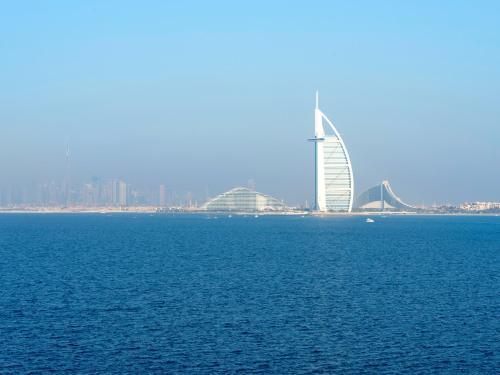 a large body of water with a building in the background at Luxury Apartments in Anantara Resort with Stunning Burj AlArab & Sea Views in Dubai