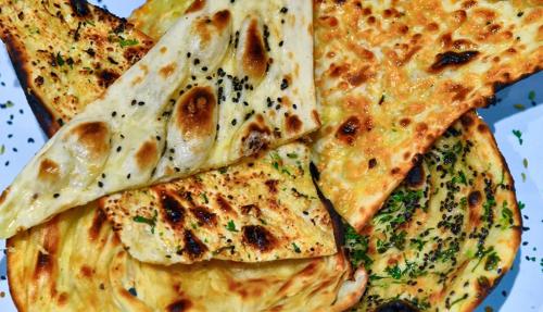 a plate of food with pizza on it at Shahi Corporate Hotel,Near Mumbai International Airport T-2 in Mumbai