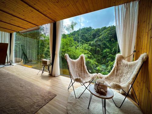 Habitación con 2 sillas y ventana grande. en Morning Star Glamping, en Ban Pok Nai