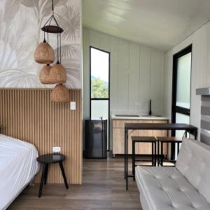 a bedroom with a bed and a table and a kitchen at Cabaña Valle del Cocora in Salento