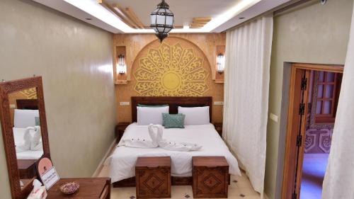 a bedroom with a large bed with white sheets at Dar Chams Ouarzazate in Ouarzazate