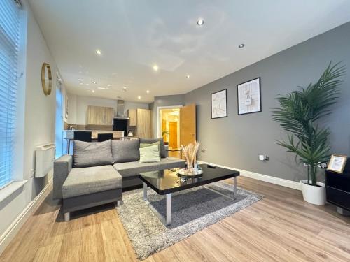 a living room with a couch and a table at Modern TWO Bedroom Apartment Birmingham City Centre - 2 BATHROOMS - SLEEPS 6 GUESTS - FREE Underground Parking - FAST Speed Internet in Birmingham