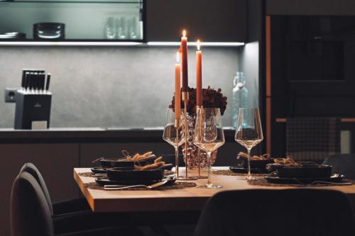 a table with candles and plates of food and wine glasses at Aloha Suite - Schladming Dachstein in Haus im Ennstal
