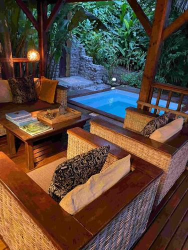 a patio with a pool and a table and chairs at Rêve Et Alizé - Gites de charme in Bouillante