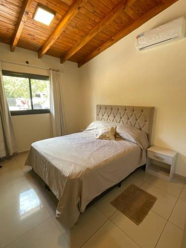 Un dormitorio con una cama en una habitación con ventana. en Casareartesesok, en Los Reartes