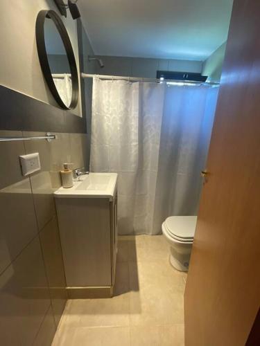 Un baño con inodoro, lavabo y espejo. en Casareartesesok, en Los Reartes