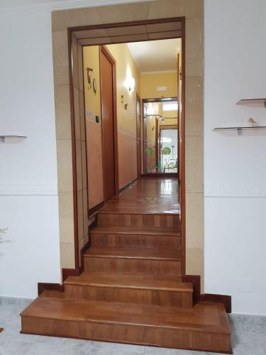 a hallway with wooden stairs in a building at La casa di Devdi in Mottola