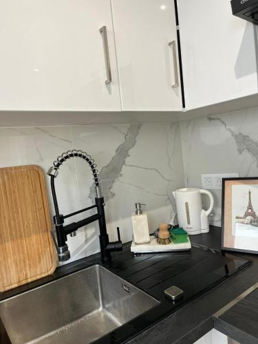 - un comptoir de cuisine avec évier dans l'établissement studio confort aux portes de paris, parking, jardin, à Villejuif