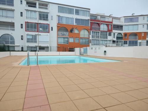 une piscine vide en face d'un bâtiment dans l'établissement Cap d'Agde duplex l'Olivier vue mer 5 à 6 pers, au Cap d'Agde