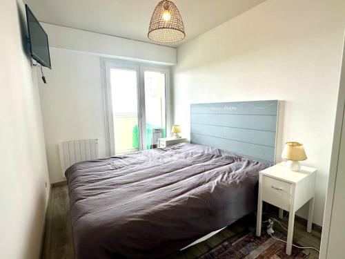 une chambre avec un grand lit et une télévision dans l'établissement Pieds dans l'eau vue mer, à Saint-Hilaire-de-Riez