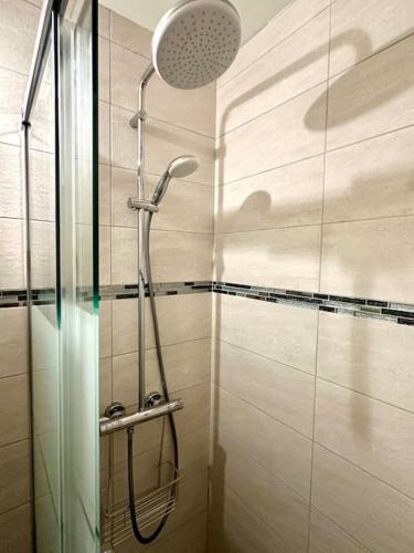 une douche avec une porte vitrée dans une salle de bain dans l'établissement Pieds dans l'eau vue mer, à Saint-Hilaire-de-Riez