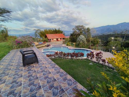 a house with a swimming pool and a tv on a patio at Finca La Vistosa in Sasaima