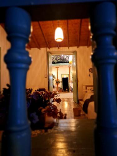 a hallway with a blue pillar and a living room at Hostal Prana in Abejorral