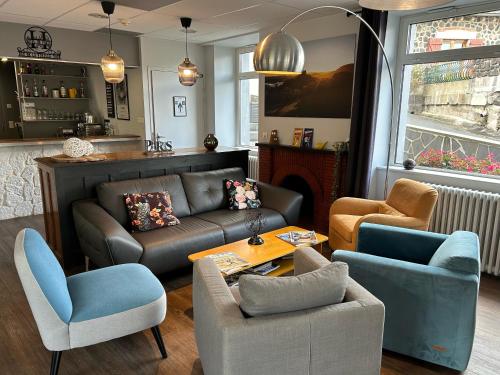 a living room with a couch and chairs and a table at Logis Hôtel de Paris in Murol