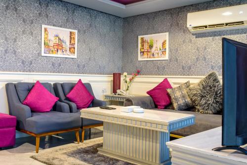 a living room with two couches and pink pillows at Royal Day in 6th Of October