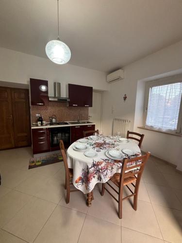 a dining room table with chairs and a white table cloth at L'alloggio turistico di Zoe in Tuscania