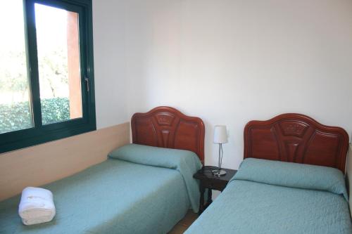 a room with two beds and a window at Casas Golf Relax in Pals
