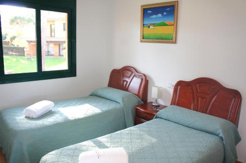 a room with two twin beds and a window at Casas Golf Relax in Pals