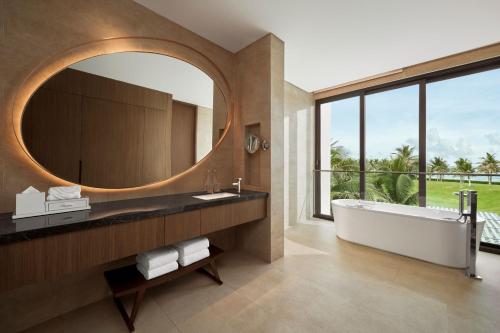 a bathroom with a tub and a large mirror at The Westin Resort & Spa Cam Ranh in Cam Ranh