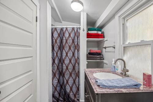 een badkamer met een wastafel en een douche bij Historic William Smith House -- Pet Friendly, Grill, Wifi, Fire Pit, Deck, Family Friendly, Town Location, King Bed, Creekside in Berkeley Springs