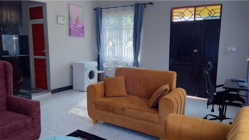 a living room with a couch and a chair at Otoria Apartments Home away from Home in Dar es Salaam