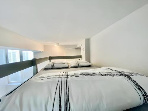 un grand lit blanc dans une chambre avec une fenêtre dans l'établissement SAINT PATRICE, à Rouen