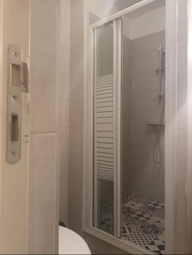 une salle de bain avec une douche avec une porte vitrée dans l'établissement Hôtel de Lorraine, à Paris