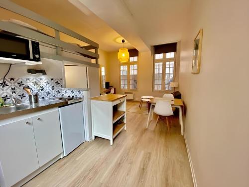 une cuisine avec des armoires blanches et une table et des chaises dans l'établissement SAINT PATRICE, à Rouen