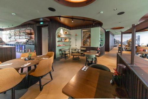 a restaurant with wooden tables and chairs and a bar at Stadsherberg de Wijnberg in Bolsward
