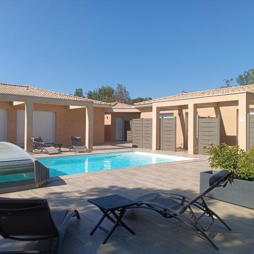une villa avec une piscine et deux chaises dans l'établissement Domaine Chante-Cevennes, à Frouzet