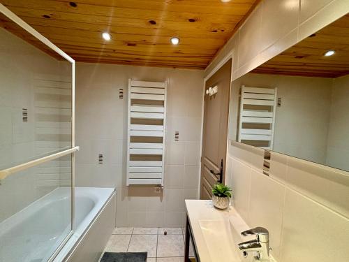 une salle de bain avec une baignoire et un lavabo dans l'établissement Charmant T3 proche du centre de Châtel - Multipass inclu, à Châtel