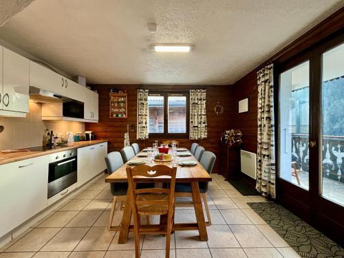 une cuisine avec une table et des chaises dans une pièce dans l'établissement Charmant T3 proche du centre de Châtel - Multipass inclu, à Châtel