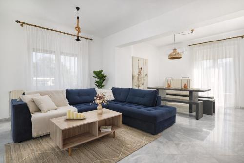 a living room with a blue couch and a table at Villa Felenia in Vryses