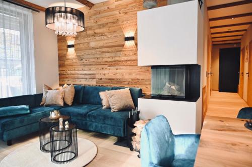 a living room with a blue couch and a fireplace at Aloha Suite - Schladming Dachstein in Haus im Ennstal