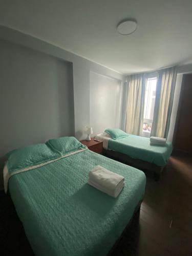 a hotel room with two beds and a window at Ravenala - Apartment Paracas in Paracas