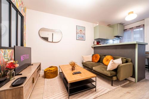 a living room with a couch and a table at Le Ferrer - Wifi - Netflix - Free Parking - Métro in Lille